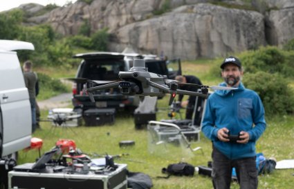 Drone med dronepilot i bakgrunnen