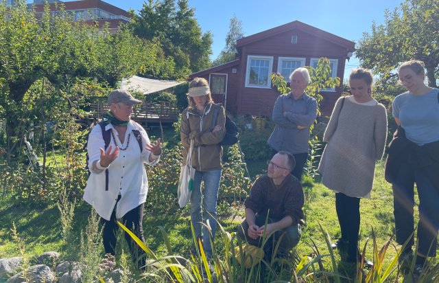 Person forklarer til liten forsamling utendørs